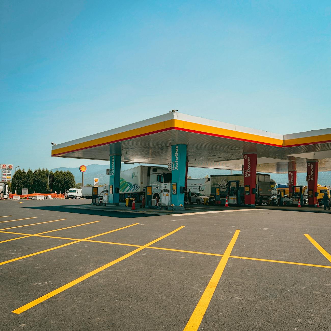 Modern gas station in İstanbul under clear blue sky. Wide-angle view with empty parking lot.